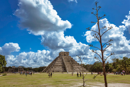 Tourists walking on the lawn in front of the kukulkan pyramid at the Chichen Itza archaeological...