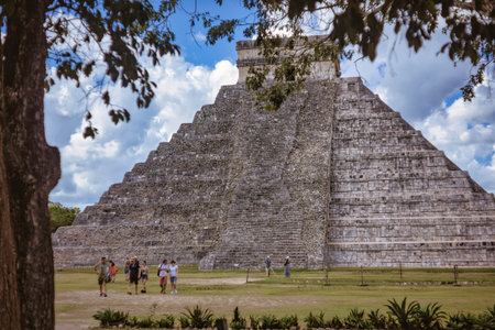 Tourists walking near the majestic kukulkan pyramid, also known as el castillo, at the chichen itza...