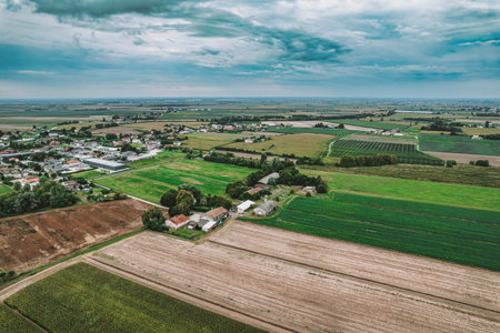 Aerial view captures the patchwork of cultivated fields and scattered farmhouses in the valley,...