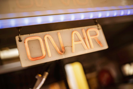 On air neon sign glowing in a dark radio studio, evoking live broadcasting, retro media production and communication, perfect for audio, podcast and entertainment themesの写真素材