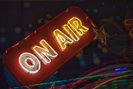 On air neon sign illuminating in a dark setting, symbolizing live broadcasting, podcasting, and entertainment culture with its vibrant glow and vintage aestheticの写真素材
