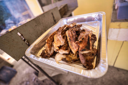 Freshly grilled pork pieces remaining in an aluminum tray, juicy and smoky, ready to serve at outdoor parties, buffets or catering events for summer gatherings and picnicsの写真素材