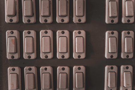 Rovigo, Italy 18 December 2025: array of vintage power control switches on an aged wall panel, illustrating concepts of electricity management and outdated technologyのeditorial素材