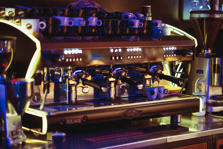 Rovigo, Italy 18 December 2025: commercial espresso machine pouring fresh shots into small cups on a busy cafe counter, steam rising in warm morning lightのeditorial素材