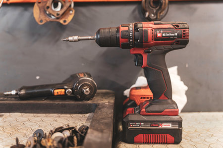 Rovigo, Italy 18 December 2025: cordless drill with screwdriver bit and impact wrench in a garage or workshop setting, highlighting power tools and diyのeditorial素材