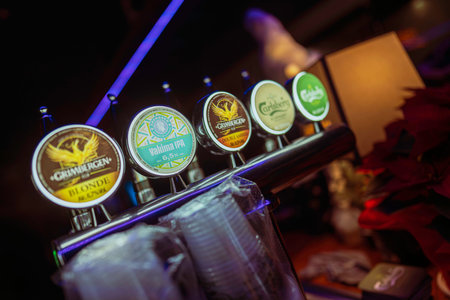 Rovigo, Italy 18 December 2025: beer taps lined up on a pub counter offering a variety of draft brands like grimbergen, valima ipa and carlsberg for patronsのeditorial素材