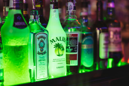 Rovigo, Italy 18 December 2025: alcohol bottles, including Bombay Sapphire and Malibu, are...