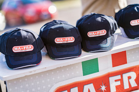 Imola, italy 01 january 2026: mafra branded baseball caps displayed on a table with italian flag...