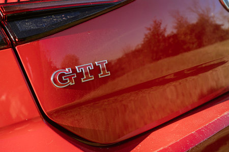 Imola, italy 01 january 2026: red volkswagen gti emblem on glossy hatchback tailgate, close-up showing chrome badge, sleek modern automotive design detailのeditorial素材