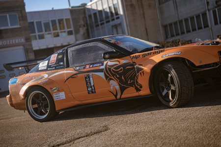 Imola, italy 01 january 2026: orange nissan 240sx race car featuring a tiger decal and sponsor...