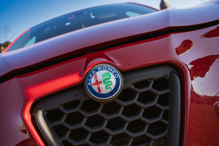 Imola, italy 01 january 2026: alfa romeo emblem with biscione and red cross on glossy red sports car grille, close-up showcasing italian heritage and performanceのeditorial素材