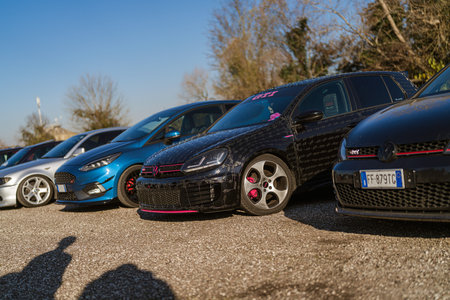 Imola, italy 01 january 2026: line of customized cars including volkswagen golf gti and ford focus parked outdoors on a sunny day â tuning culture showcaseのeditorial素材