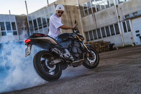 Imola, italy 01 january 2026: motorcyclist performing a dramatic burnout on urban asphalt, tires...