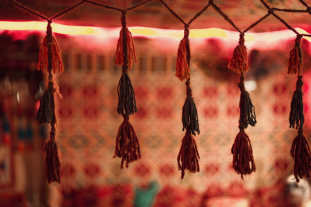 Bedouin tent interior showing handcrafted tassels hanging above a colorful patterned textile, reflecting traditional middle eastern decor found in marsa alam, egypt