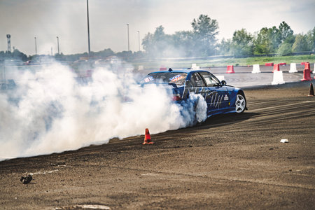 Milan, italy 21 april 2026: blue performance car drifting hard on track, kicking up thick tire smoke during an adrenaline-fueled motorsport event