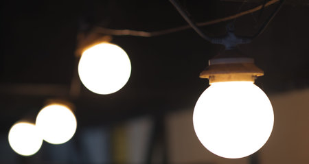 A group of 4 light bulbs in a line on a dark background
