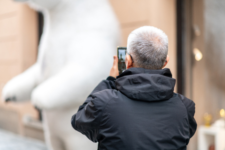 Old Asian Male tourist takes photos whilst sightseeing in Prague, Czech Republic - Easter Holidays April 2019の写真素材