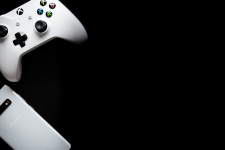 A phone and controller sit side by side as gaming becomes multi-platformのeditorial素材