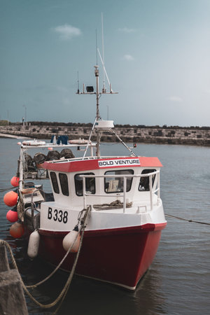 NORTHERN IRELAND, UK - 8TH APRIL 2019: A bright red fishing boat called Bold Venture is moored at a...