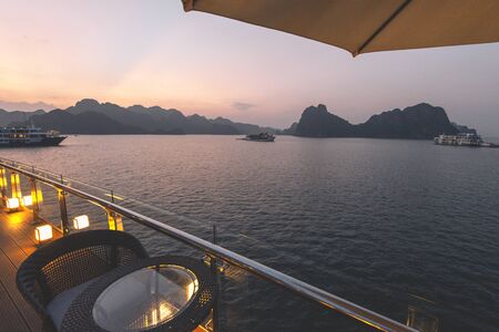 5 Star luxury on new modern Cruise Ships on Ha Long Bay, Vietnam looking over the stunning limestone rocks at Sunsetの写真素材