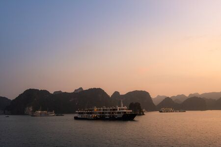 Ha Long Bay in Vietnam during a beautiful Sunset with calm, tranquil seas. Shot in Autumn 2019 from a cruise ship tourの写真素材