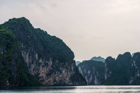 Ha Long Bay in Vietnam during a beautiful Sunset with calm, tranquil seas. Shot in Autumn 2019 from a cruise ship tourの写真素材