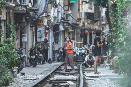 Hanoi, Vietnam - 18th October 2019: Tourists take photos whilst standing on the tracks at Train Street in Hanoi, Vietnamのeditorial素材