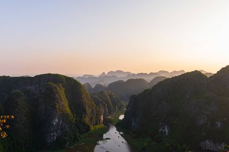 Beautiful sunset over Vietnamese rivers and Landscape from the scenic Mua Caves and Dragon Statue in Tam Coc, Ninh Binh, Vietnamの写真素材