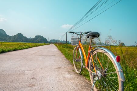 Close up of bike near a rice field in the beautiful countryside of rural Vietnamの写真素材
