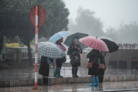 Sapa, Vietnam - 13th October 2019: Local Sapa woman waiting for tourists to sell gifts as they are dropped off on tour bussesのeditorial素材