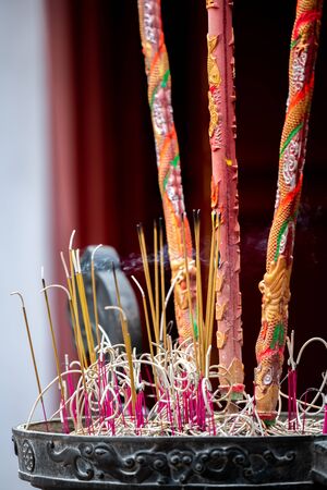 Lots of small and large Red incense sticks burning in front of a buddist temple in Hanoi, Vietnamの写真素材