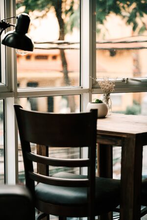 Coffee table next to a bright window with a relaxing and tranquil atmosphere for customers to enjoy coffee and foodの写真素材