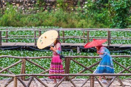 Tourists take photos against the fields of flowers in the small little mountain village of Cat Catの写真素材