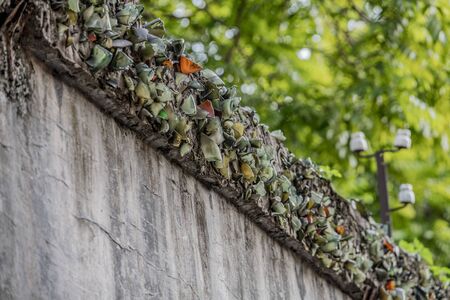 Smashed glass bottles are stuck on the top of a wall to prevent prisoners escaping from the Hanoi Hotel political prison in Vietnamの写真素材