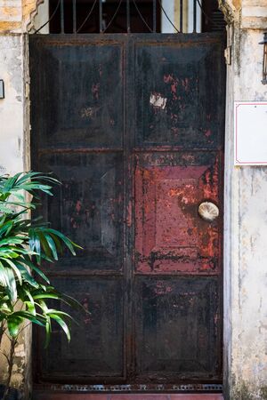 A old rusy black metal door found in a back side alley in Hanoi, Vietnamの写真素材