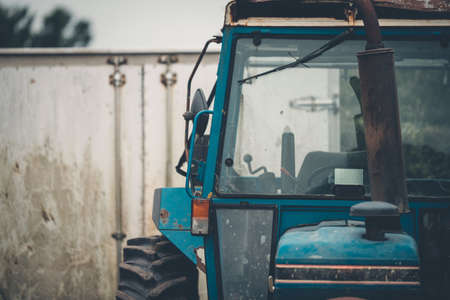An abandoned old blue tractor stored in a field in the UK with overcast skiesの写真素材