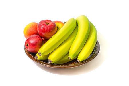 Bananas and apples on the dish with white background.の写真素材