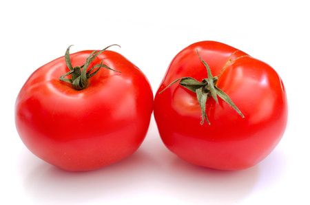Two whole tomatoes on the white background.の写真素材