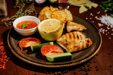 Dish with fried potatoes with meat on a plate on a wooden tableの写真素材