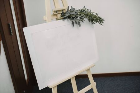Blank white poster on a stand on a holiday close up. White poster on a stand. Poster blank on a tripod.の写真素材