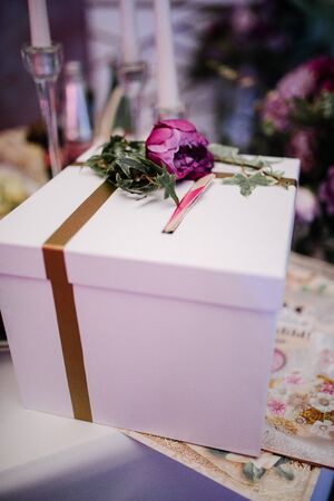 A cardboard gift box with a bow is on the table. Packed gift for the holidayの写真素材