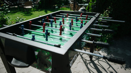 People play table football in the open air. People play table football.