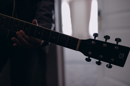 Man playing guitar indoors closeup