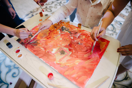 The artist paints a picture on canvas with paints close up