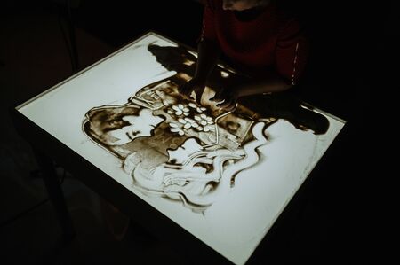 The artist draws sand. Animation on the sand. Drawing sand on glassの写真素材