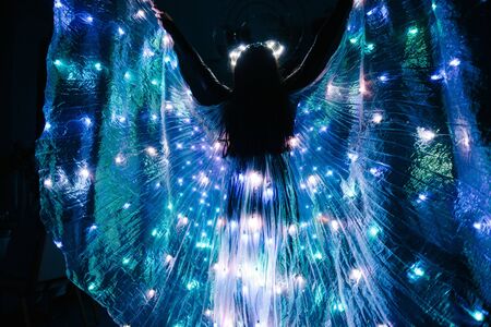 People in luminous costumes dance in the dark for a holidayの写真素材