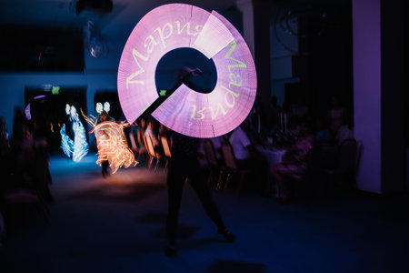 People in luminous costumes dance in the dark for a holiday