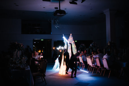 People in luminous costumes dance in the dark for a holiday