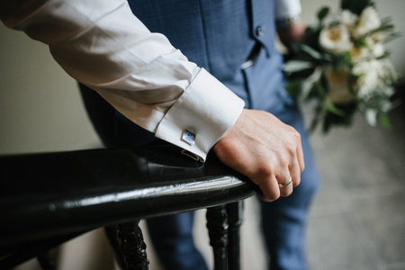 A man in a suit holds a wedding bouquet of flowers