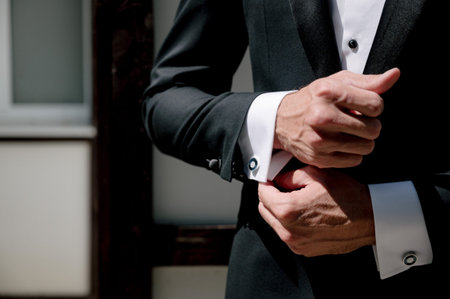 Closeup of elegant young fashion man dressing up for wedding celebration. Color close up image of...